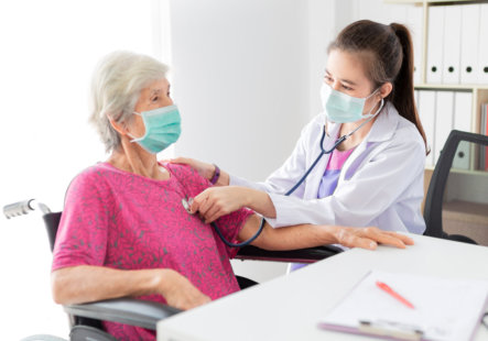 medical professional checking senior patient